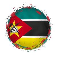 Round grunge flag of Mozambique with splashes in flag color. vector