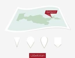 curvo papel mapa de Uzbekistán con capital Tashkent en gris antecedentes. cuatro diferente mapa alfiler colocar. vector