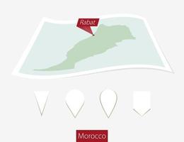 Curved paper map of Morocco with capital Rabat on Gray Background. Four different Map pin set. vector