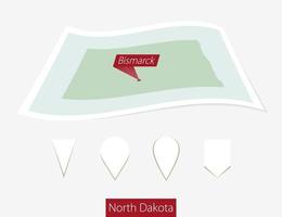 Curved paper map of North Dakota state with capital Bismarck on Gray Background. Four different Map pin set. vector