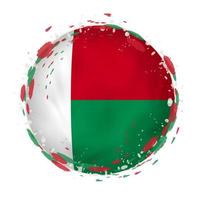 Round grunge flag of Madagascar with splashes in flag color. vector