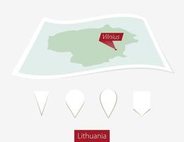 curvo papel mapa de Lituania con capital Vilnius en gris antecedentes. cuatro diferente mapa alfiler colocar. vector