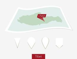 Curved paper map of Tibet with capital Lhasa on Gray Background. Four different Map pin set. vector