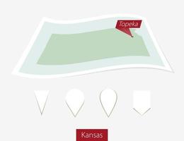 Curved paper map of Kansas state with capital Topeka on Gray Background. Four different Map pin set. vector