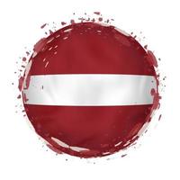 Round grunge flag of Latvia with splashes in flag color. vector