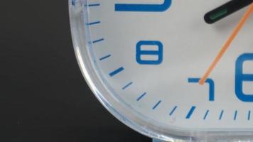 Blue-and-white clock with numbers of two sizes displayed and hands pointing in different directions. video