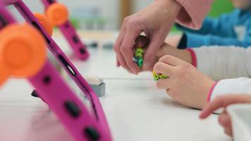 kinderen Speel met Lego en creëren programmeerbaar robotten. detailopname van robotica. video