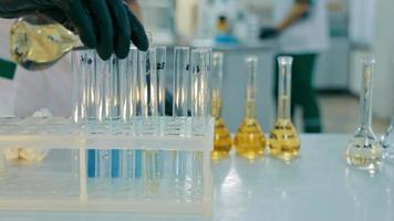 Close-up Of Pouring A Yellow Chemical Solution Into Test Tubes. Work In The Laboratory With Chemicals In Flasks And Test Tubes. video