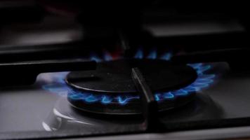 Ignition of the gas burner on the stove in the kitchen. Use of natural resources, economy, cooking on fire. Close-up