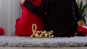 homme et femme amoureux à la maison sont assis près du poêle à bois avec un feu brûlant sur un tapis confortable. saint valentin, couple heureux, histoire d'amour, relations video