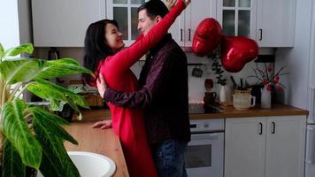 hombre y mujer enamorados citan en casa en la cocina felices abrazos. día de san valentín, pareja feliz, historia de amor. nido de amor, vivienda para familia joven video