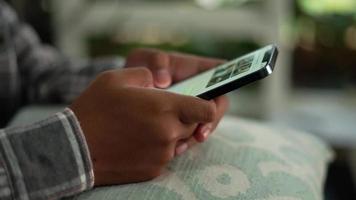 homem sentado vestindo uma travesseiro e digitando em uma Smartphone video