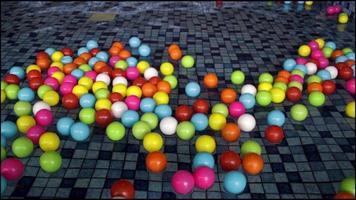 Lot of colorful kids play ball floating at kids swimming pool. video