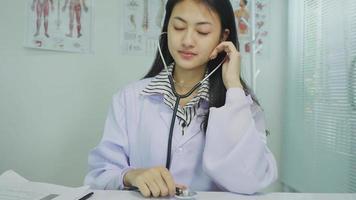 sonriente joven mujer médico cardiólogo vistiendo blanco médico Saco y estetoscopio demostración manos corazón forma mirando a cámara. cardiología cuidado de la salud, amor y medicina caridad concepto, retrato. video