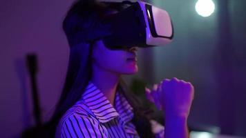 vrouw gebruik makend van virtueel realiteit koptelefoon en op zoek in de omgeving van Bij interactief technologie tentoonstelling met kleurrijk verlichting. vr, futuristisch, retrogolf, meeslepend, vermaak concept video