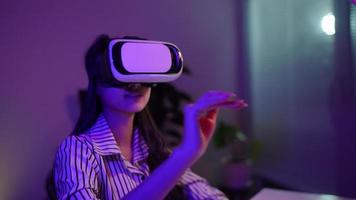 Woman using virtual reality headset and looking around at interactive technology exhibition with colorful illumination. VR, futuristic, retrowave, immersive, entertainment concept video