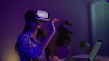 donna utilizzando virtuale la realtà cuffia e guardare in giro a interattivo tecnologia esposizione con colorato illuminazione. vr, futuristico, retroonda, coinvolgente, divertimento concetto video