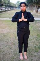 joven india practicando yoga al aire libre en un parque. hermosa chica practica pose básica de yoga. calma y relax, felicidad femenina. posturas básicas de yoga al aire libre foto