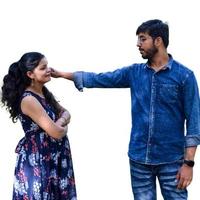 Indian couple posing for maternity baby shoot with white plain background. The couple is posing in a lawn with green grass and the woman is falunting her baby bump in Lodhi Garden in New Delhi, India photo