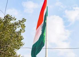 India flag flying high at Connaught Place with pride in blue sky, India flag fluttering, Indian Flag on Independence Day and Republic Day of India, tilt up shot, Waving Indian flag, Har Ghar Tiranga photo