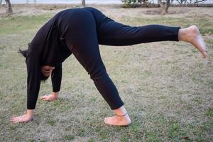 Young Indian woman practicing yoga outdoor in a park. Beautiful girl practice basic yoga pose. Calmness and relax, female happiness. Basic Yoga poses outdoor photo