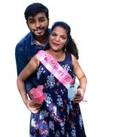 Indian couple posing for maternity baby shoot with white plain background. The couple is posing in a lawn with green grass and the woman is falunting her baby bump in Lodhi Garden in New Delhi, India photo