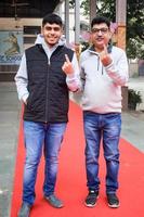 New Delhi, India - December 04 2022 - Unidentified people showing their ink-marked fingers after casting votes in front of polling booth of east Delhi area for MCD local body Elections 2022 photo