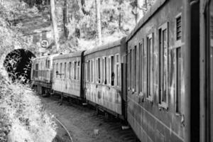 Shimla, Himachal Pradesh, India - May 14, 2022 - Toy train Kalka-Shimla route, moving on railway to the hill, Toy train from Kalka to Shimla in India among green natural forest photo