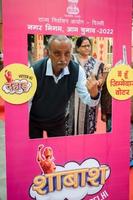 New Delhi, India - December 04 2022 - Unidentified people showing their ink-marked fingers after casting votes in front of polling booth of east Delhi area for MCD local body Elections 2022 photo