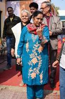 New Delhi, India - December 04 2022 - Unidentified people showing their ink-marked fingers after casting votes in front of polling booth of east Delhi area for MCD local body Elections 2022 photo