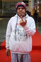 New Delhi, India - December 04 2022 - Unidentified people showing their ink-marked fingers after casting votes in front of polling booth of east Delhi area for MCD local body Elections 2022 photo