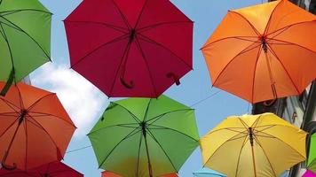 Walking under colored umbrellas. Bottom to top view. Slow motion footage video