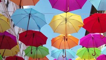 Walking under colored umbrellas. Bottom to top view. Slow motion footage video