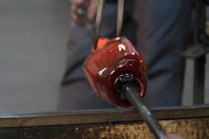 maestro de vidrio mientras trabajaba en la fábrica de vidrio de horno de murano venecia italia foto