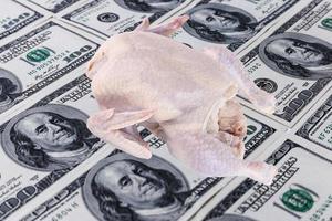 Raw chicken carcass on the background of US paper banknotes. food crisis. photo