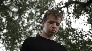 Sad, Melancholy Young Man Stands Under Trees video