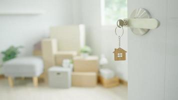 Moving house, relocation. The key was inserted into the door of the new house, inside the room was a cardboard box containing personal belongings and furniture. move in the apartment or condominium video