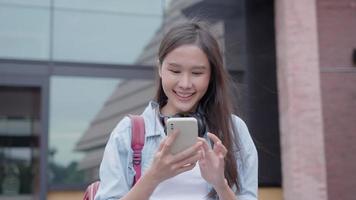 hermosa mujer asiática salió de la expresión de la cara de sorpresa. la mujer se siente sorprendida con el teléfono. sonrisa emocionante y feliz adorable se regocija. muy disfrutar y divertirse relajarse tiempo. guau, chica sosteniendo un teléfono inteligente. video