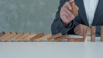 försäkring med händer skydda domino. affärsman händer sluta domino faller i företag kris. företag risk kontrollera och planera och strategier till springa förhindra försäkring företag. video