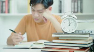 asiatische studenten haben angst wegen prüfungen, männliche bereiten sich auf prüfungen vor und lernen unterricht in der bibliothek. Stress, Verzweiflung, Eile, missverstandenes Lesen, entmutigt, Erwartung, Wissen, müde