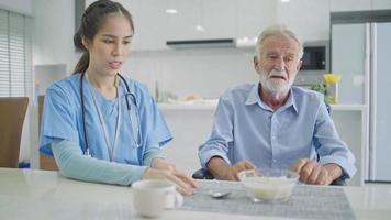 Senior male patient rejected to eating porridge from caregiver. Upset man complain food and serious talking to female nurse. Assistant nervous to support him at nursing home