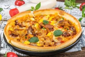 classic pizza with cheese on the table in a cafe on a wooden stand with a cut triangular piece and a pizza knife photo