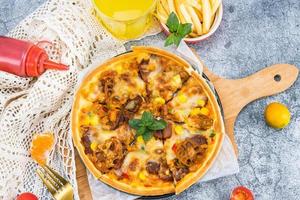 classic pizza with cheese on the table in a cafe on a wooden stand with a cut triangular piece and a pizza knife photo