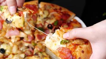 classic pizza with cheese on the table in a cafe on a wooden stand with a cut triangular piece and a pizza knife photo