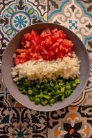 Tomato, green pepper and onion cut into dice in a bowl photo