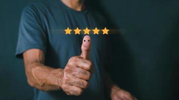 Customer satisfaction concept. Hand with thumb up Positive emotion smiley face icon and five star with copy space. satisfaction rating photo