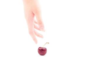 humano mano con rojo Cereza aislado en blanco antecedentes. el Cereza es un Fruta con sustancial medicinal y nutricional cualidades. foto
