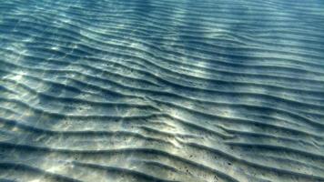 fondo de arena nadando bajo el agua en la laguna turquesa foto