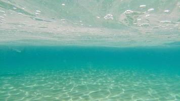 fondo de arena nadando bajo el agua en la laguna turquesa foto