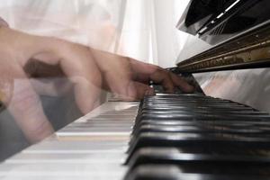 Hands playing piano while moving photo